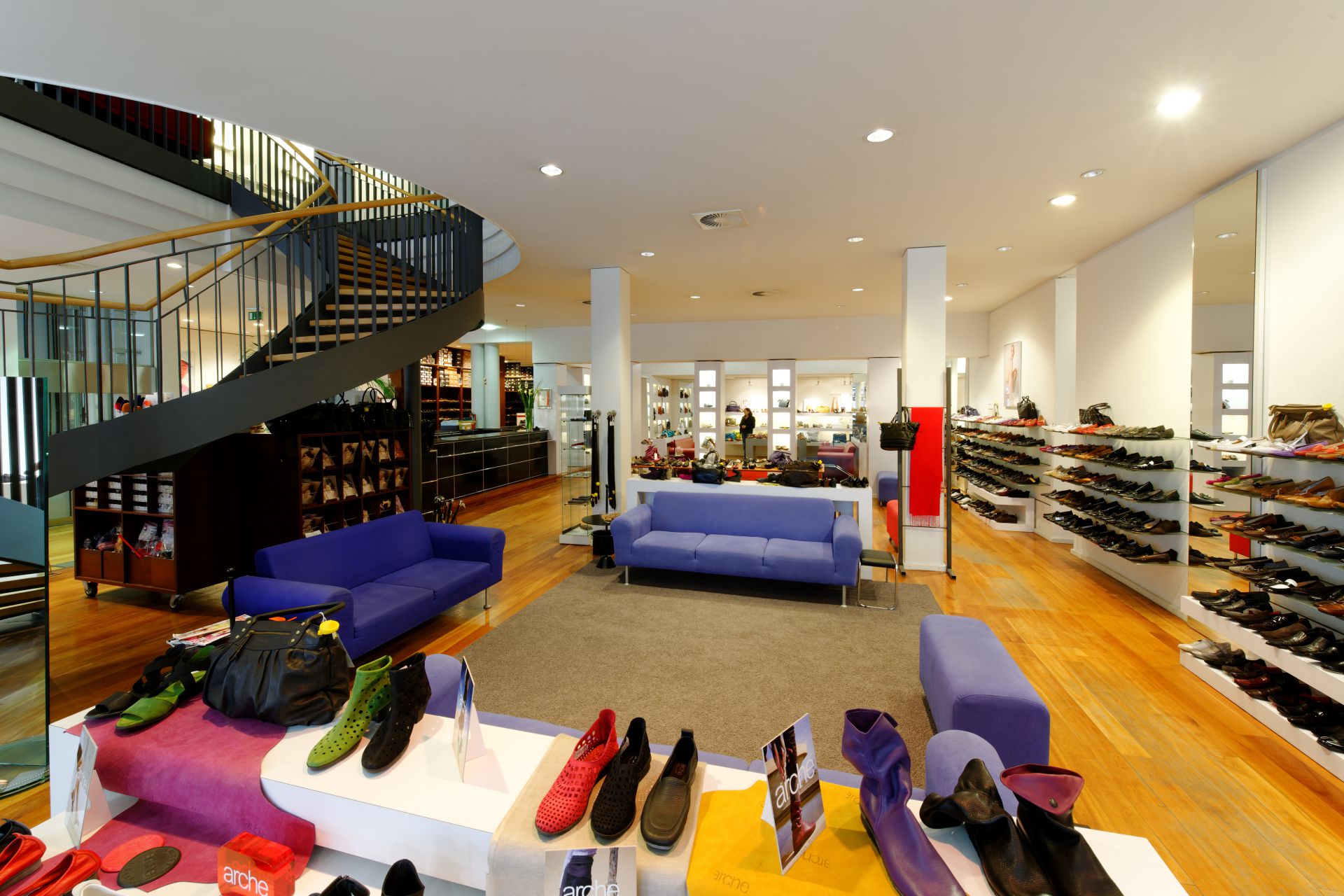 Schuhhaus Schütte Innenansicht - Treppe und violette Sofas